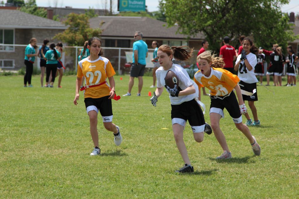 Girl is about to score a touchdown on a running play.